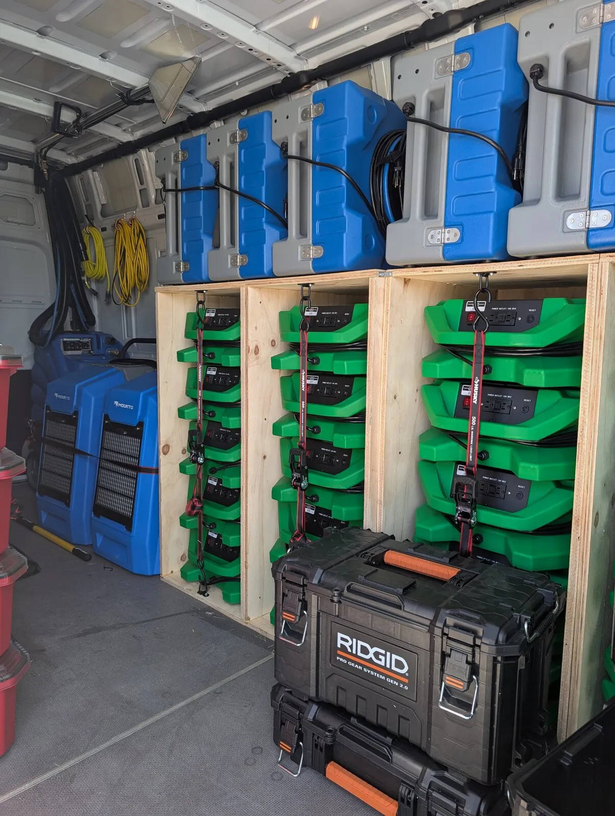 Air movers and dehumidifiers racked on shelves in the shop.