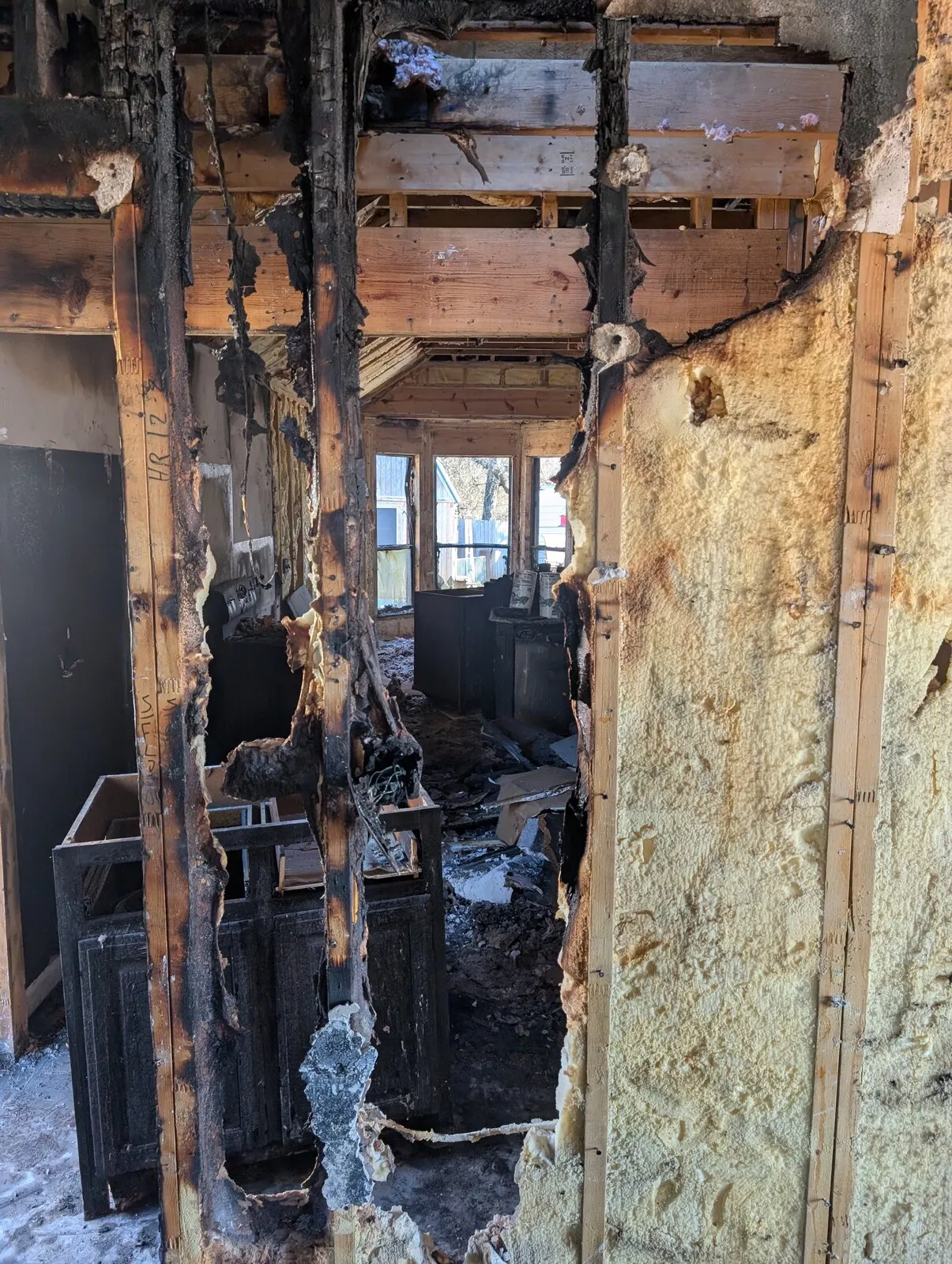 Charred wall studs with scorched insulation still between them.