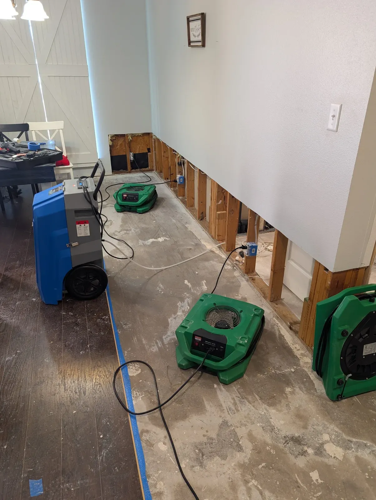 Flood cuts and drying equipment running in a water-damaged dining room