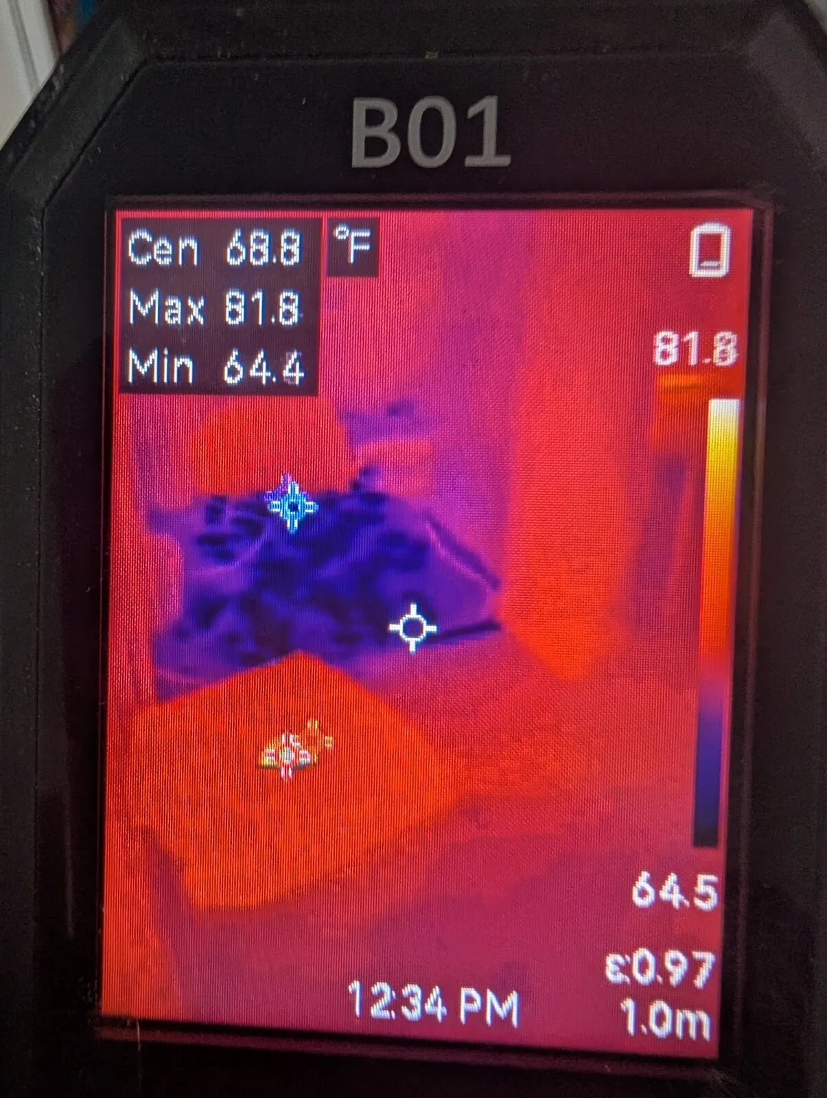 A thermal camera screen showing a cool patch across a warm surface.