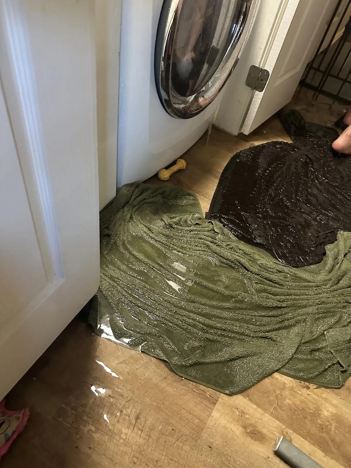 Soaked towels laid along a laundry room floor against standing water.